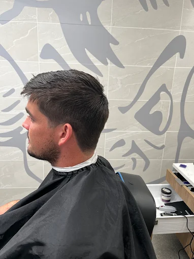 Man with a short dark haircut and a groomed beard, side view