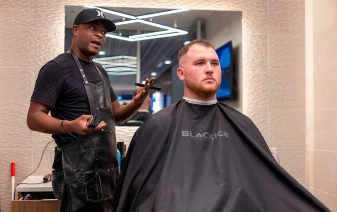Barber talking with a client during a haircut at Custom Cuts by LP