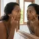 Honolulu resident with puffy eyes in Hawaii looks at her reflection in the mirror.