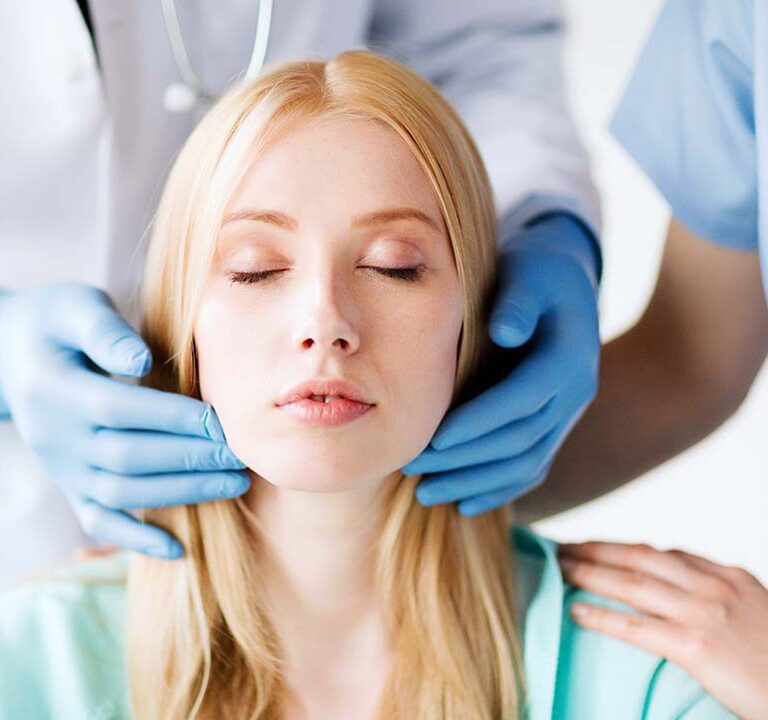 Oahu cheek fat removal surgeon in Honolulu examines patient before Oahu cheek reduction procedure, Hawaii.